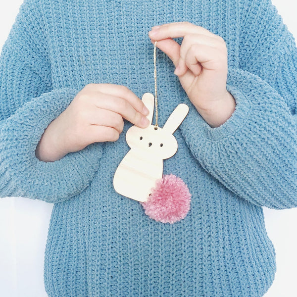 Person holding pompom bunny hanging decoration with pink pompom