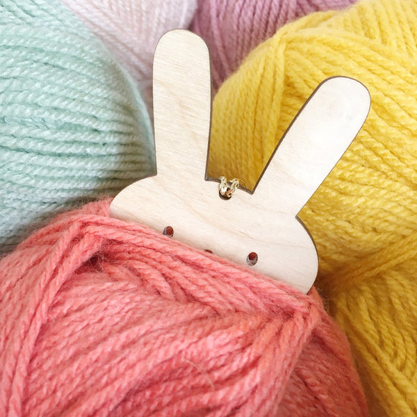 Pompom bunny peaking out of coral wool