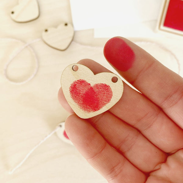 close up of heart decoration with fingerprint and finger