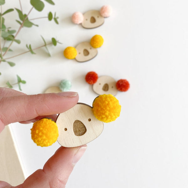 Close up of pompom koala badge with yellow pompom ears