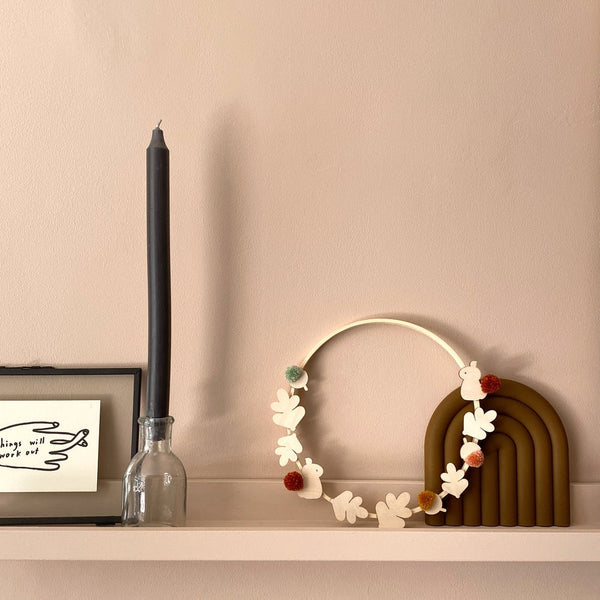 harvest hoop resting against decor in home with pompoms