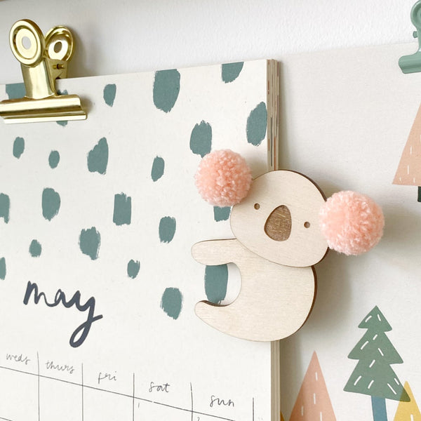 Pink pompom koala clipped onto calendar