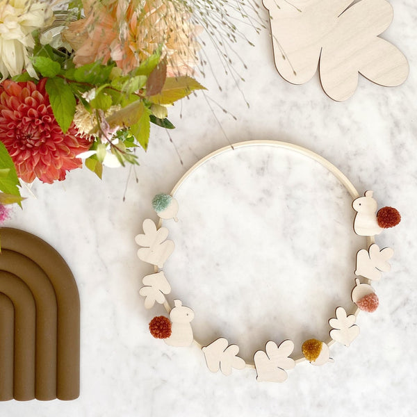 harvest hoop laid on table with pompoms