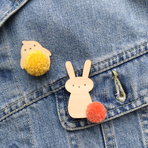 Close up of bunny and chick badges pinned onto denim jacket