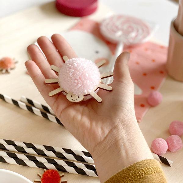 Close up of pompom spider decoration with light pink pompom