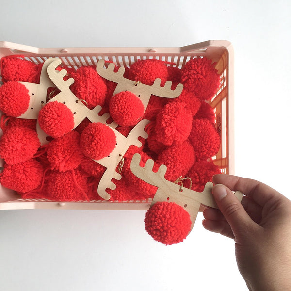 A crate full of Frank the pompom reindeer decorations with red noses
