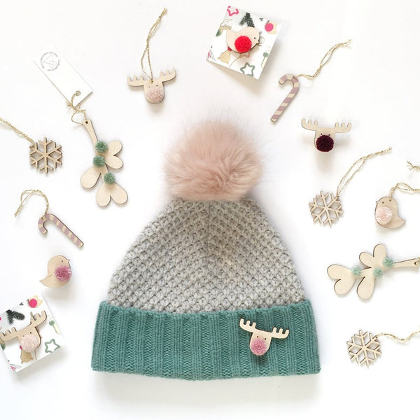 variation of christmas decorations around a bobble hat and reindeer pompom badge