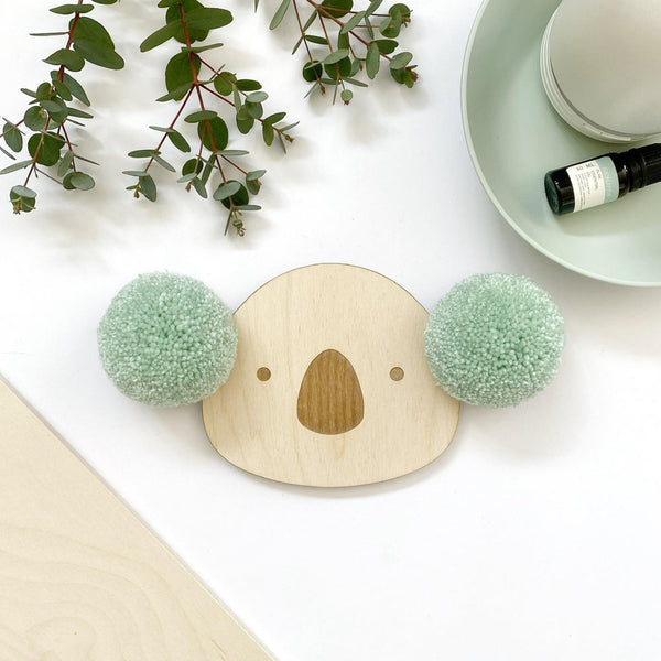 Close up of pompom koala wall plaque with eucalyptus green pompoms