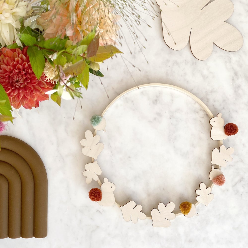harvest hoop laid on table with pompoms