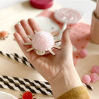 Close up of pompom spider decoration with light pink pompom