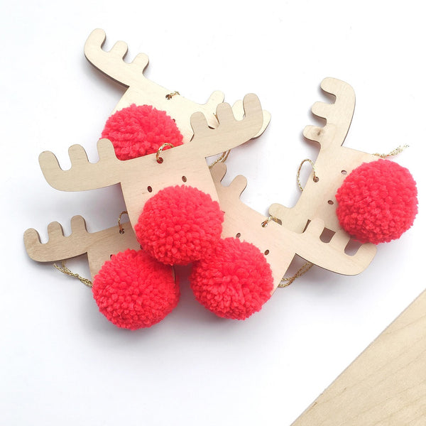 A scatter of 5 Frank  - The PomPom Reindeer decorations made from Plywood with a Classic Red PomPom nose.