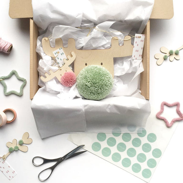 pompom reindeer in gift box with pink and green pom pom noses