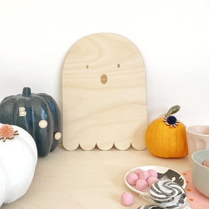 Close up of wooden ghost plaque with mini pumpkins
