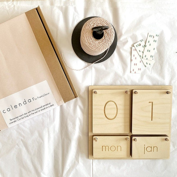 plywood calendar on bed with packaging