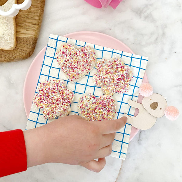 Pink koala pompom clip clipped onto plate of biscuits