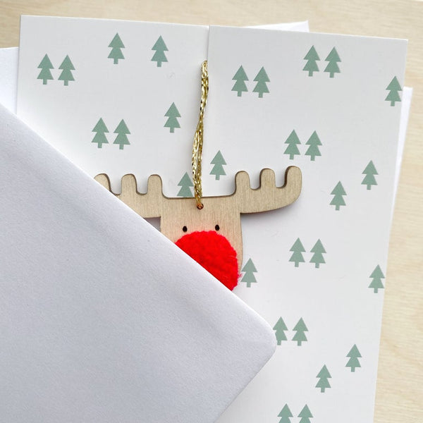 close up of merry christmas card with reindeer pompom decoration