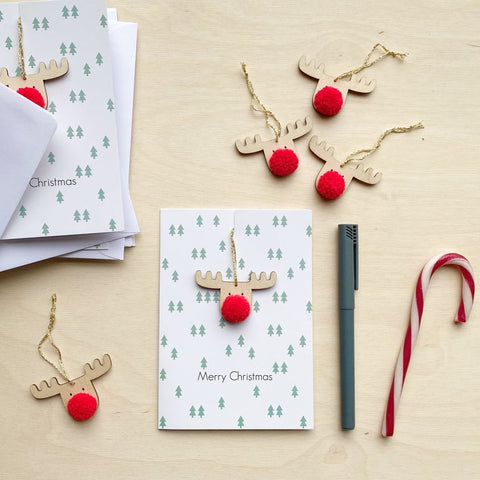 Mini Frank Christmas card - A White greetings card with green tree repeated print, Merry Christmas message and a detachable Reindeer decoration with a Red PomPom nose