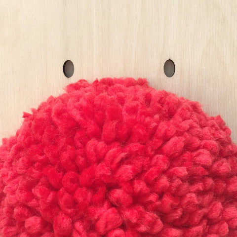 Very close up of handmade red pompom on giant reindeer frank decoration